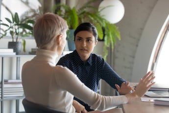 Photo of two people takling at a small table