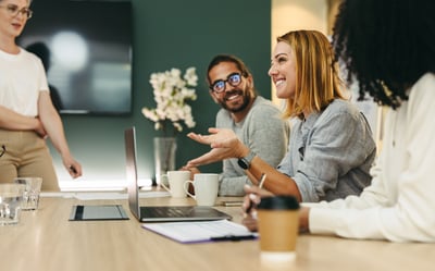 Photo of a group of employees talking at a boardroom table